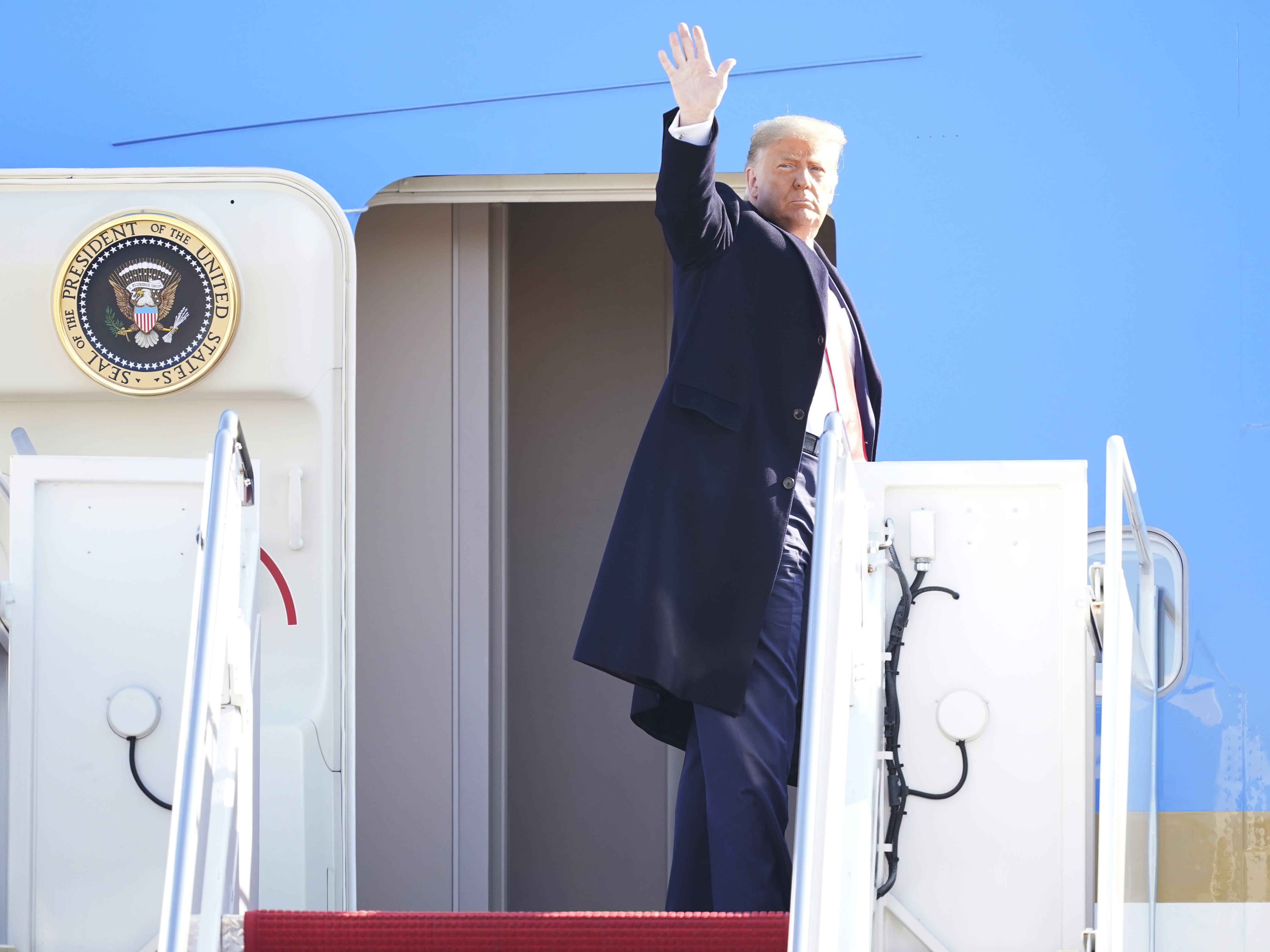 caption: President Donald Trump waves while boarding Air Force One at Joint Base Andrews before a Jan. 12 trip to Texas. He's planning a departure ceremony there on Wednesday, while skipping the traditional send-off at the Capitol.