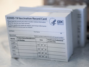 caption: A stack of COVID-19 vaccination record cards from the Centers for Disease Control and Prevention. They provide proof that you've had your shot — but aren't exactly wallet size at 4 by 3 inches.