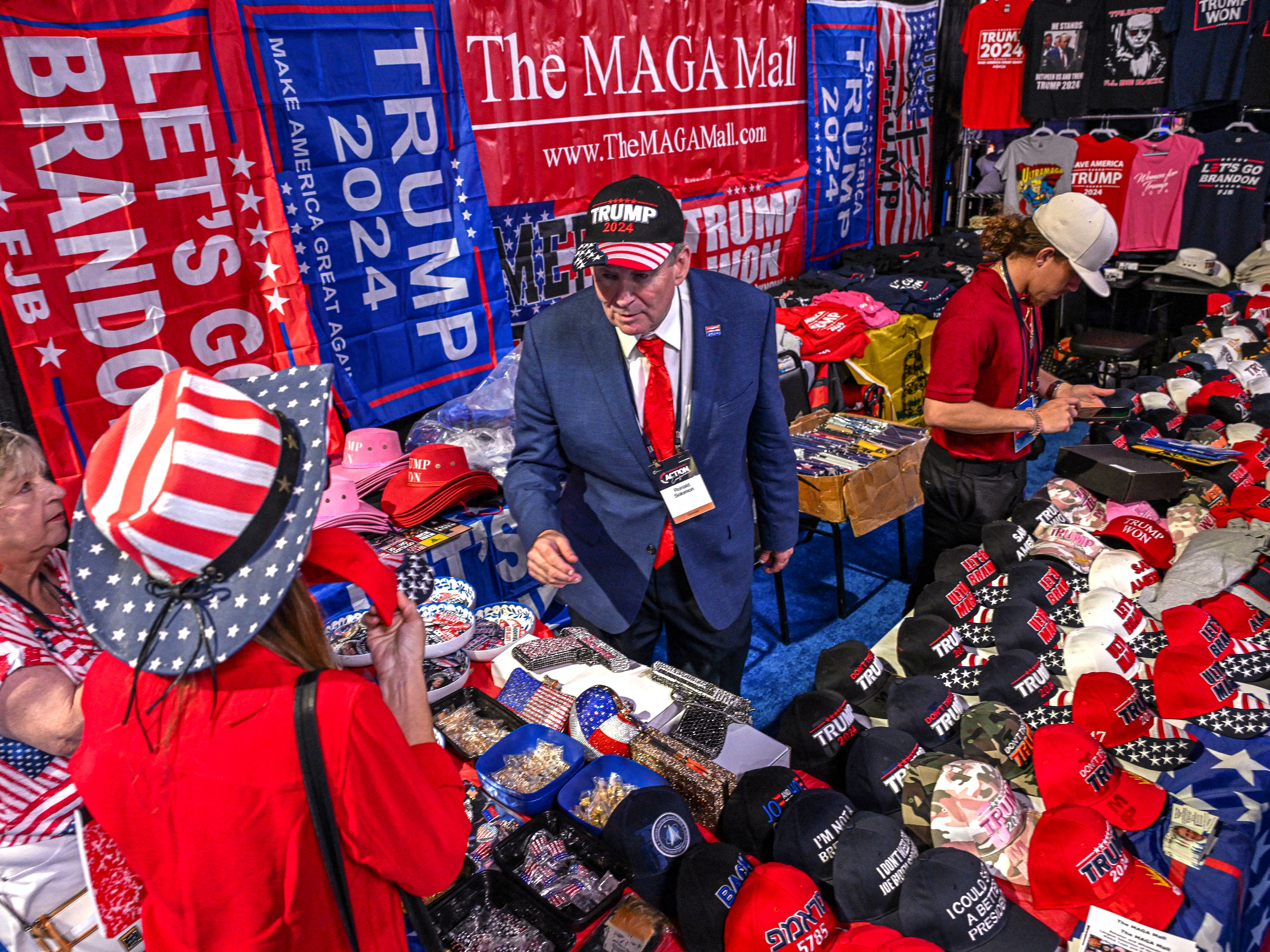 caption: A vendor sells 2024 Donald Trump campaign souvenirs at the Turning Point Action USA conference in West Palm Beach, Flo., in 2023.