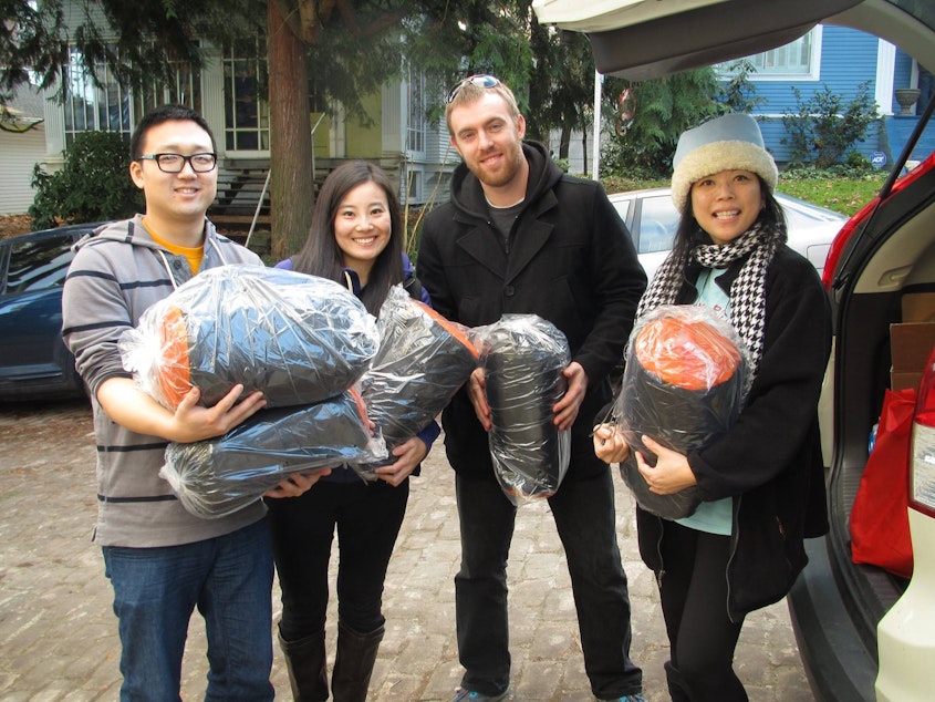 caption: Sleepless in Seattle volunteers George Bargoud, Jean (no last name given), Michael Maloy and Amiga Debbie prepared to give out sleeping bags to homeless people in King County.