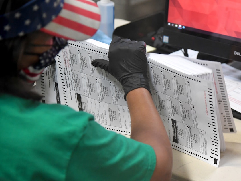 caption: A Clark County election worker scans mail-in ballots on Nov. 7 in North Las Vegas, Nevada.