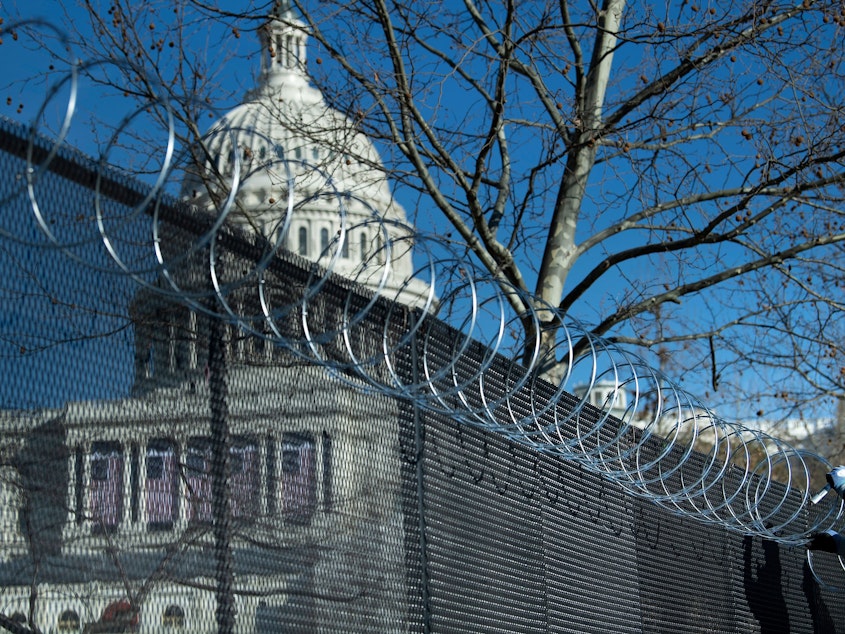 caption: Enhanced security measures, including razor wire atop a security fence surrounding the U.S. Capitol, are being implemented across the nation in preparation for next week's Presidential inauguration.