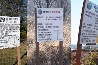 caption: Notices of proposed land use action have sprung up all over Black Diamond, WA. As the town has fought over the planned development, some of the signs have begun to gather moss.