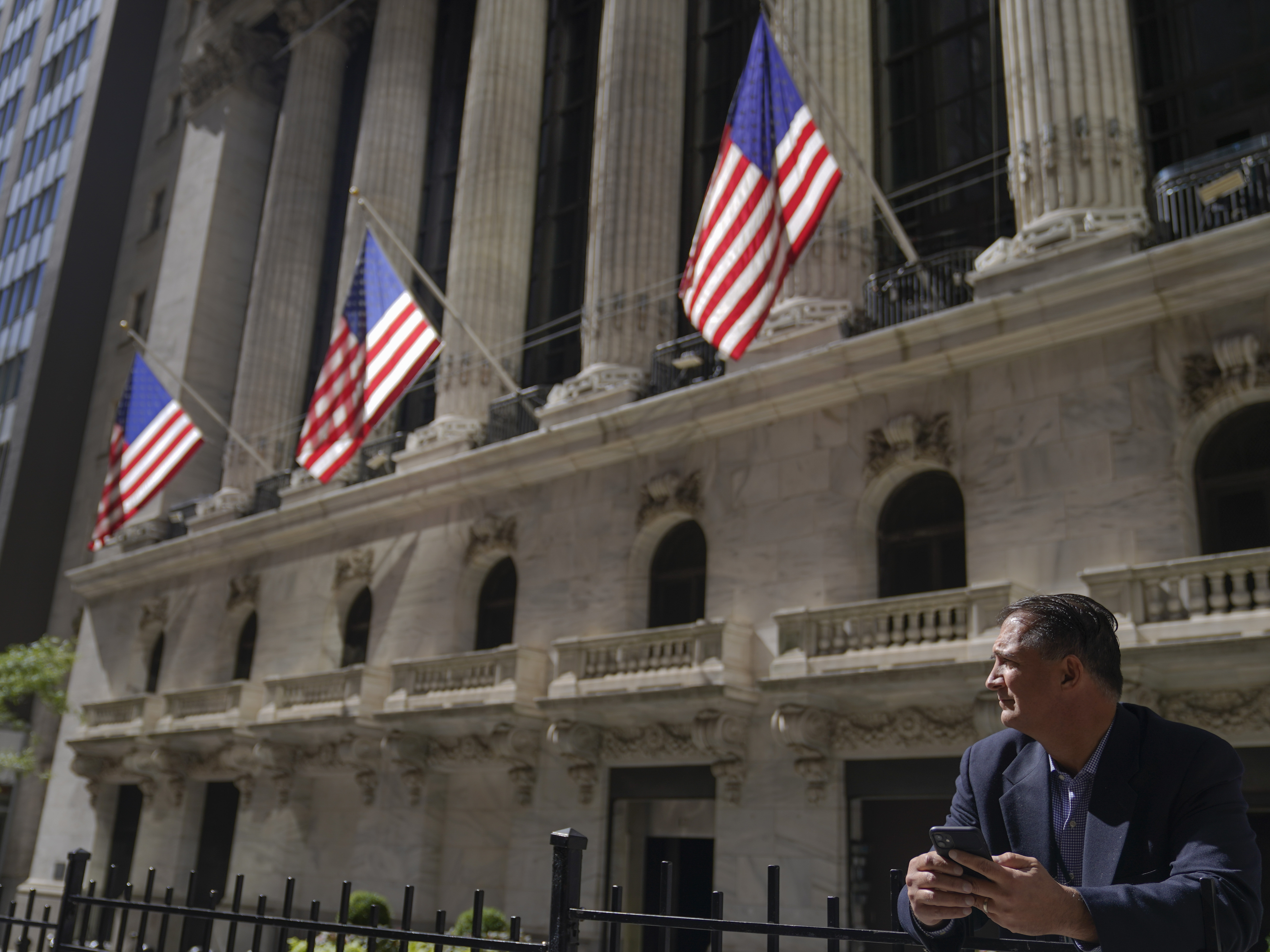 caption: A trader stands outside the New York Stock Exchange. Stocks fell Monday, giving back some of the huge gains made last week.