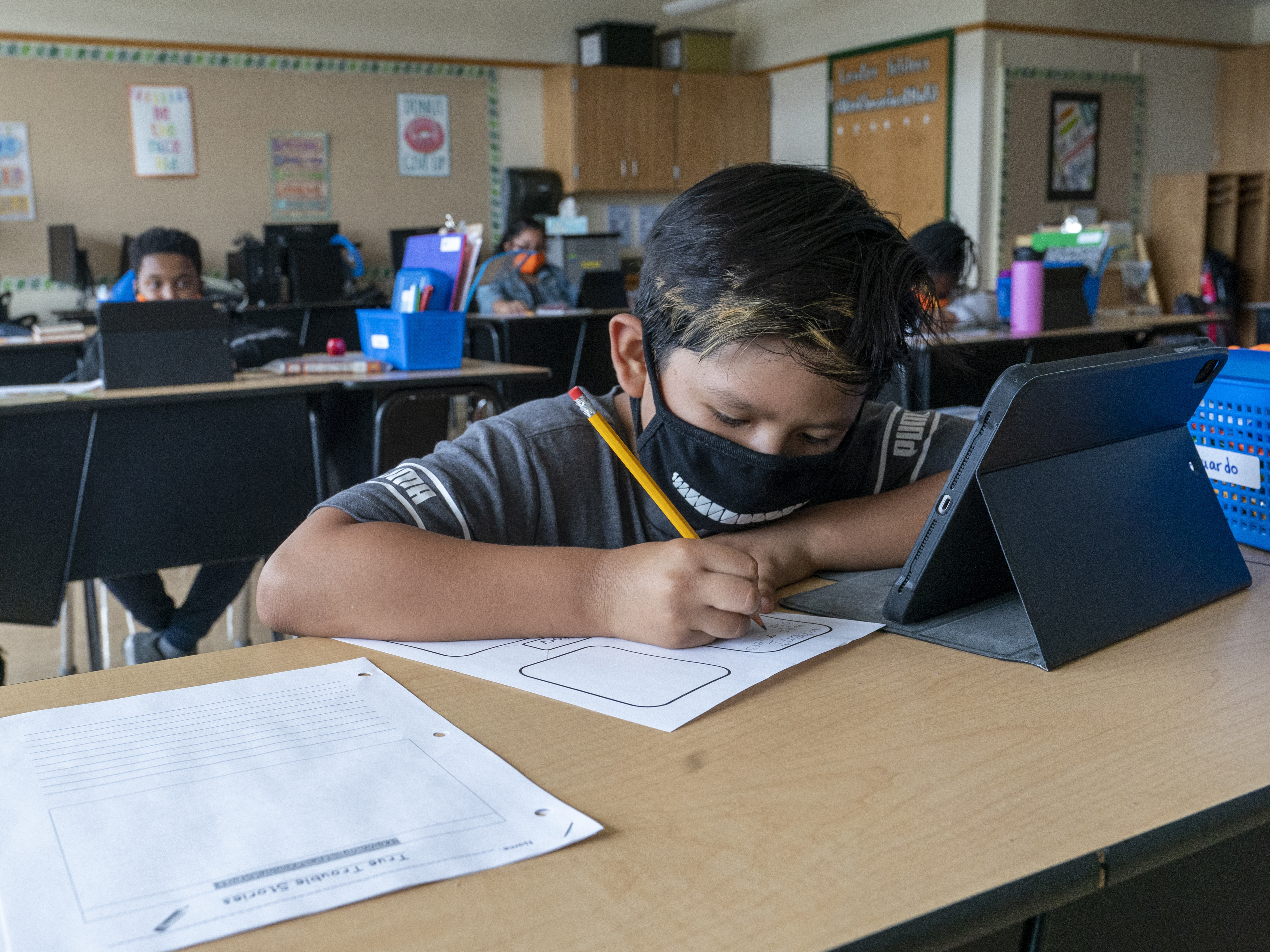 caption: A student wears a face mask while at the Post Road Elementary School in White Plains, N.Y., last October. A recent study found the number of children contracting the coronavirus is on the rise.