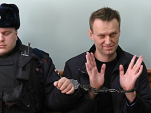 caption: Alexei Navalny rose to fame in Russia with headline-grabbing investigations into corruption in the highest levels of President Vladimir Putin's regime. Navalny (right) is seen here at a court hearing in Moscow in March 2017.
