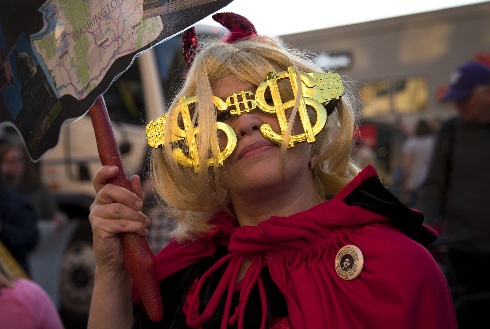 caption: Petula Lou of Bellevue stands with other protesters outside of the Hyatt Regency. Tap to see more photos.