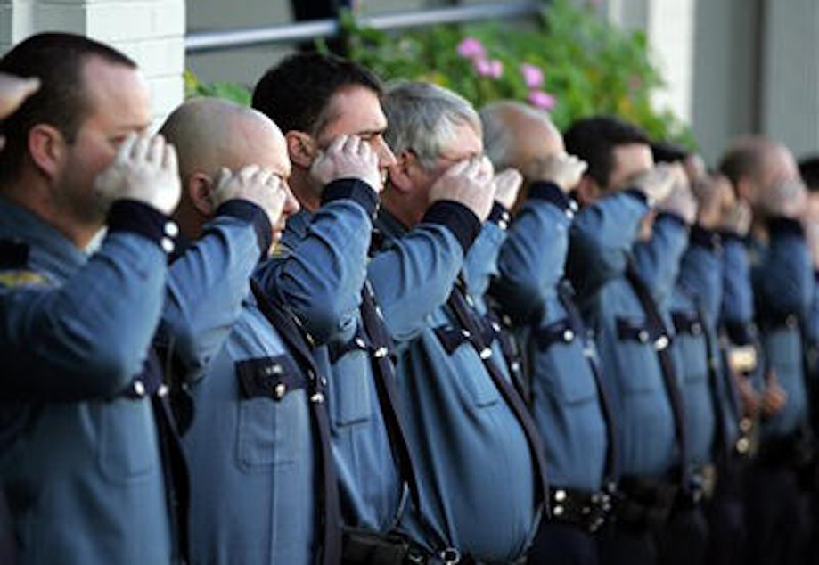 caption: Seattle Police officers at a memorial for an officer killed in 2006.