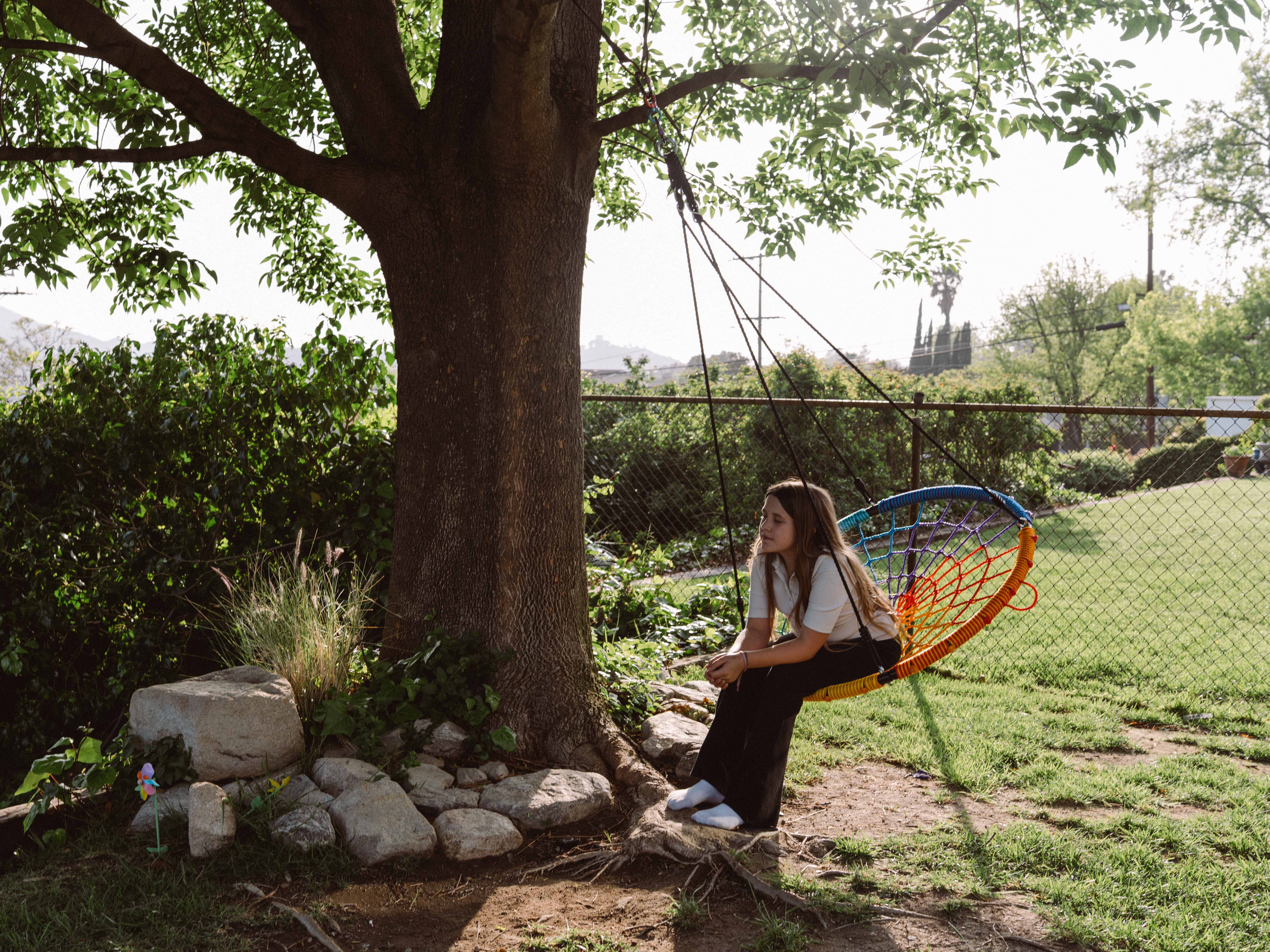 caption: Emory Stumme takes a moment to reflect on a tree swing outside of her new home in La Crescenta-Montrose, Calif.
