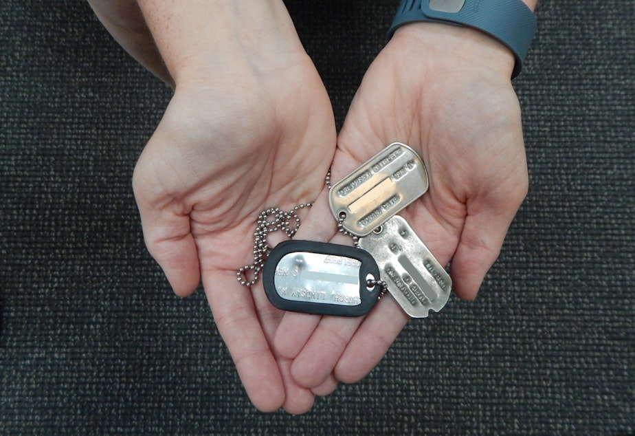 caption: Former Navy linguist Linsdsay Church holds military ID tags for her grandfather, mother and her. The two later tags contain social security numbers. The numbers have been obsured in this photo to protect thier identities.