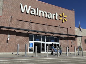 caption: Shoppers exit a Walmart store, on Feb. 21, 2024, in Englewood, Colo. Walmart on Tuesday announced layoffs affecting several hundred jobs at the retail giant's campus offices.