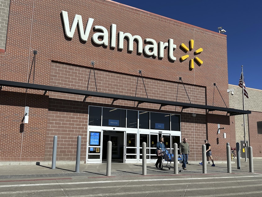 caption: Shoppers exit a Walmart store, on Feb. 21, 2024, in Englewood, Colo. Walmart on Tuesday announced layoffs affecting several hundred jobs at the retail giant's campus offices.
