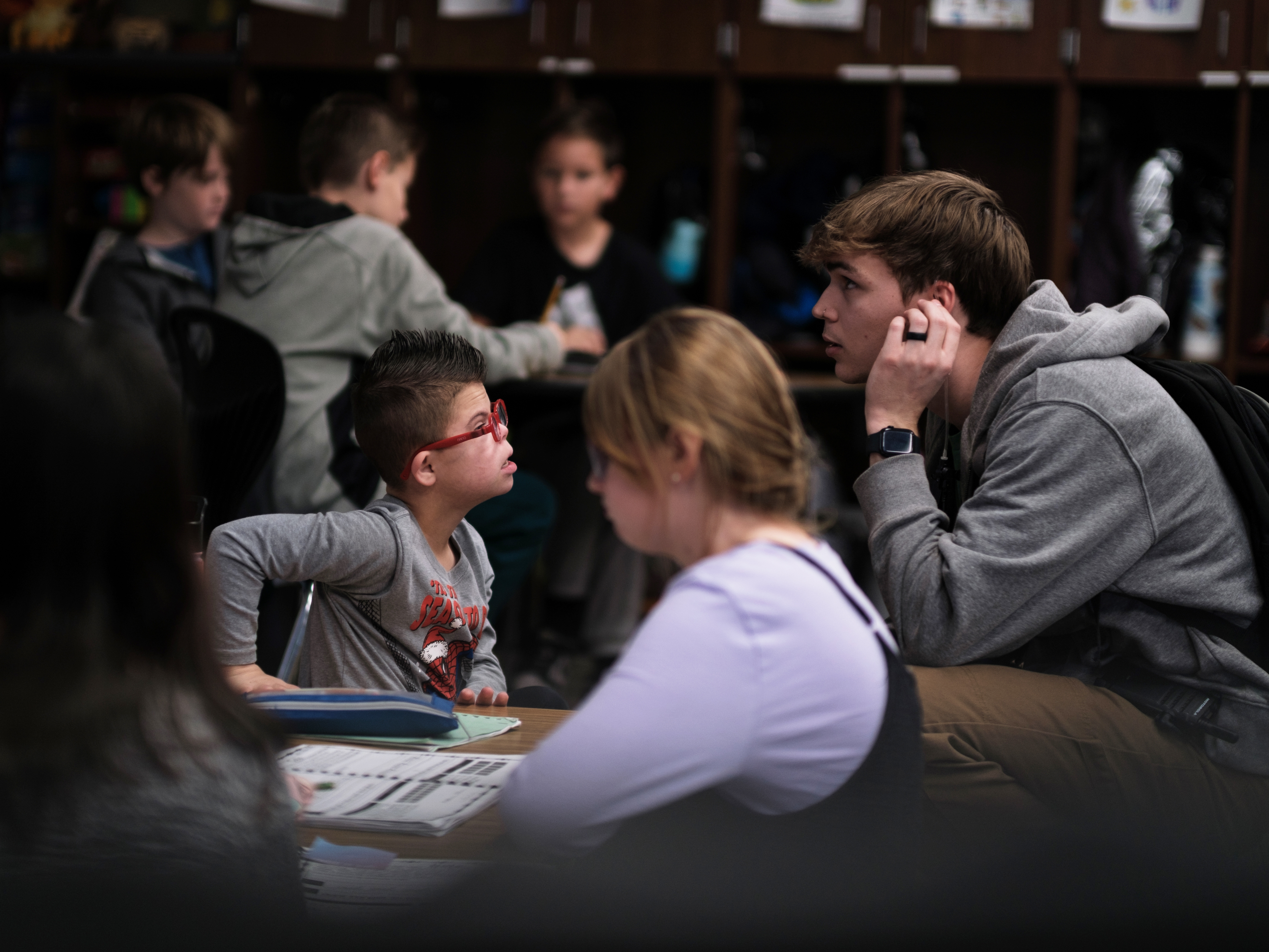 caption: Kellen Hedler's classroom aid, Parker Van Buskirk, checks in with Kellen as he works on an assignment. Kellen is largely independent throughout the school day, but Van Buskirk is available in case he needs help.