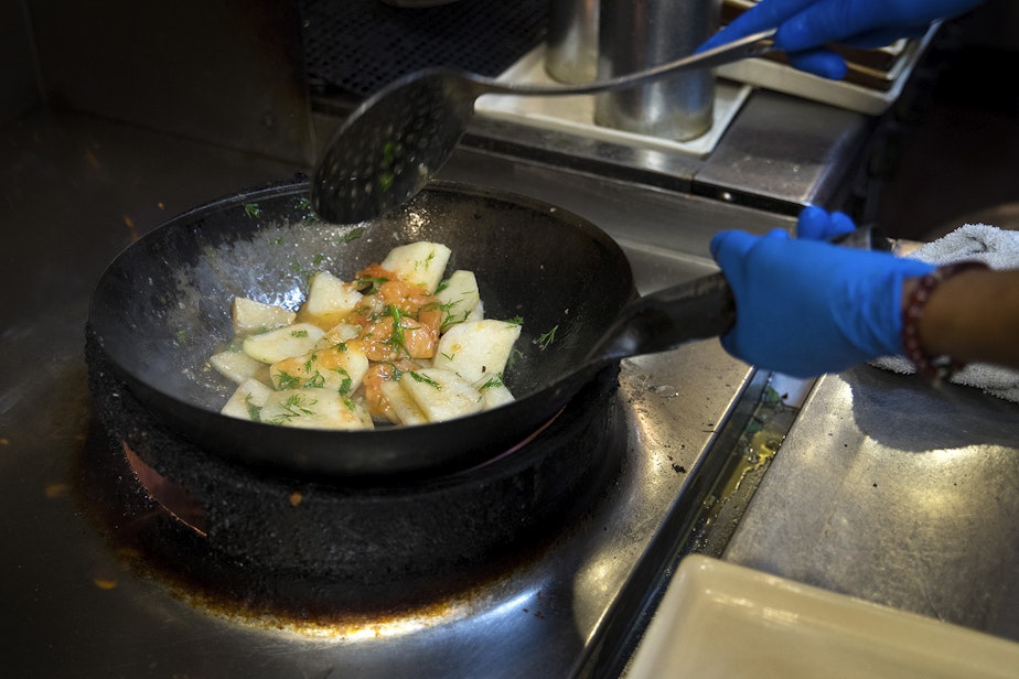 caption: FILE PHOTO: Tamarind Tree employee Lan Nguyen cooks a kohlrabi dish on Thursday, October 12, 2017, at the Vietnamese restaurant in Seattle. 