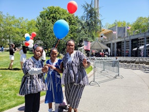 caption: Clare Adabrer and her two kids at Seattle Center during the naturalization ceremony on Thursday, July 4, 2024.