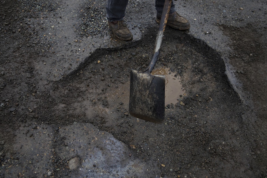 caption: Seattle Department of Transportation employee Koli Makasini gets ready to fill a pothole on Tuesday, January 8, 2019, at the intersection of South Forest Street and Occidental Avenue South in Seattle. 