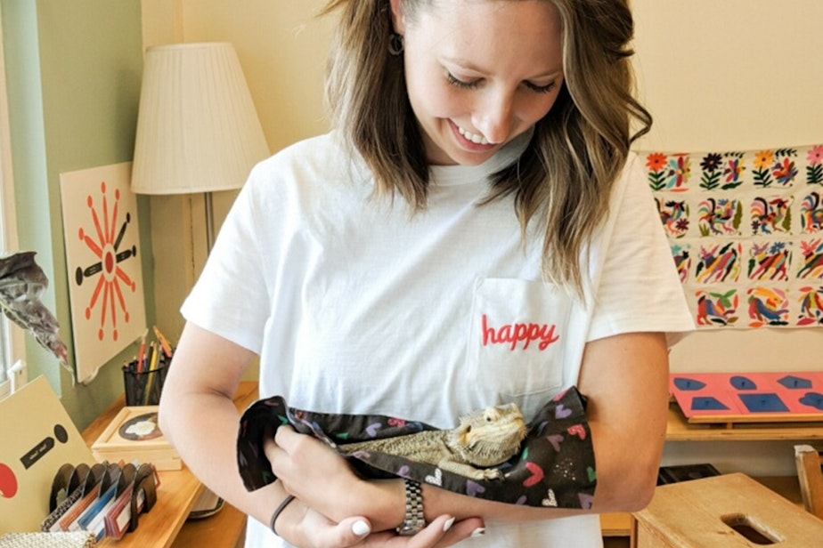 caption: Elly McCarthy in a classroom at Pacific Crest Montessori School, holding a class pet, Burnadette the Bearded Dragon! 
