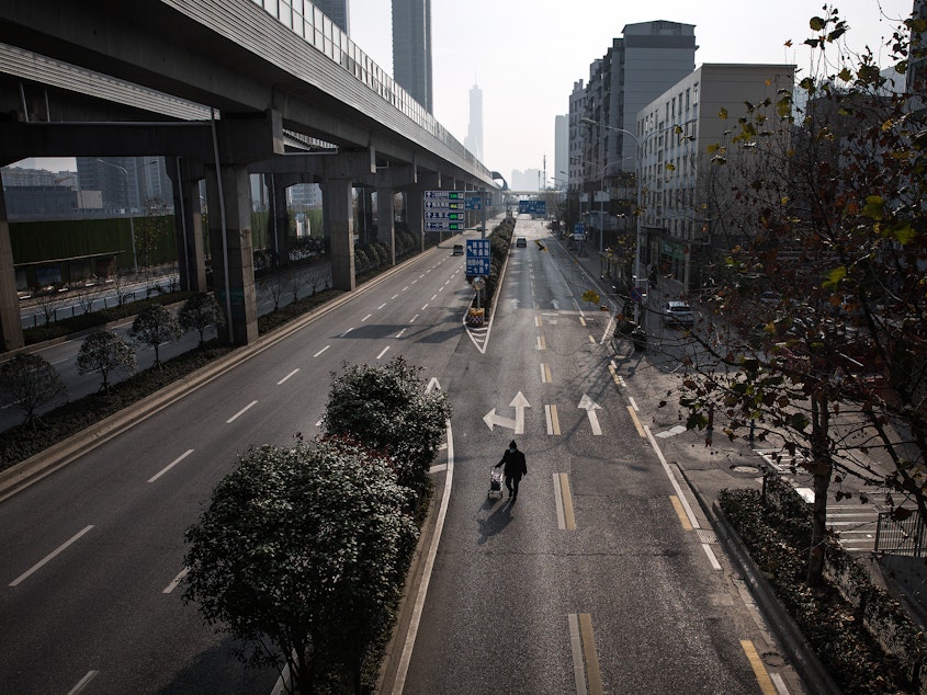 caption: The government lockdown orders in Wuhan have emptied the city's streets.