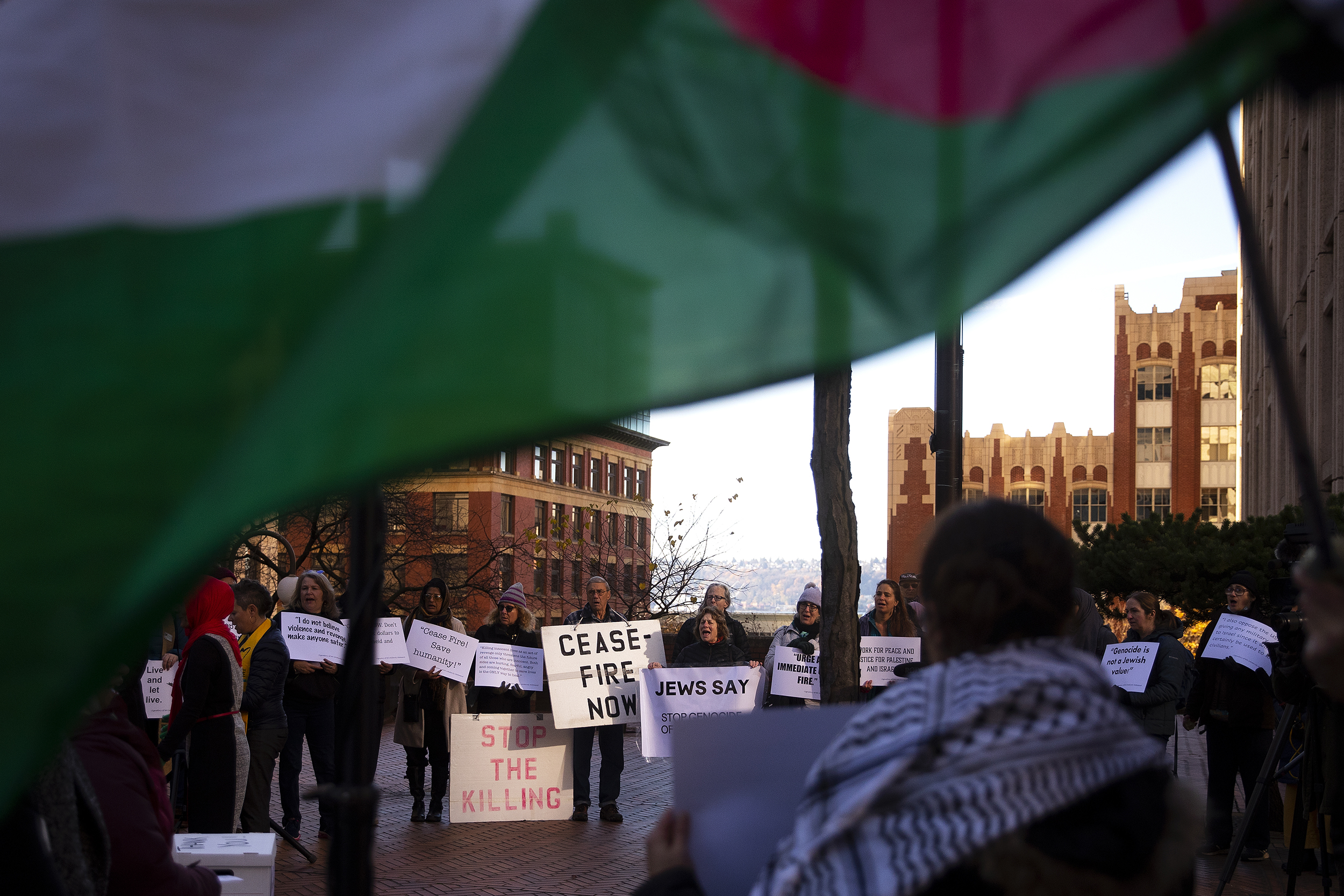 caption: ‘Stop the Killing’ and ‘Ceasefire Now’ read signs during a Multifaith solidarity gathering, calling for an immediate ceasefire in Gaza, on Thursday, November 16, 2023, outside of the Henry M. Jackson Federal Building in Seattle.