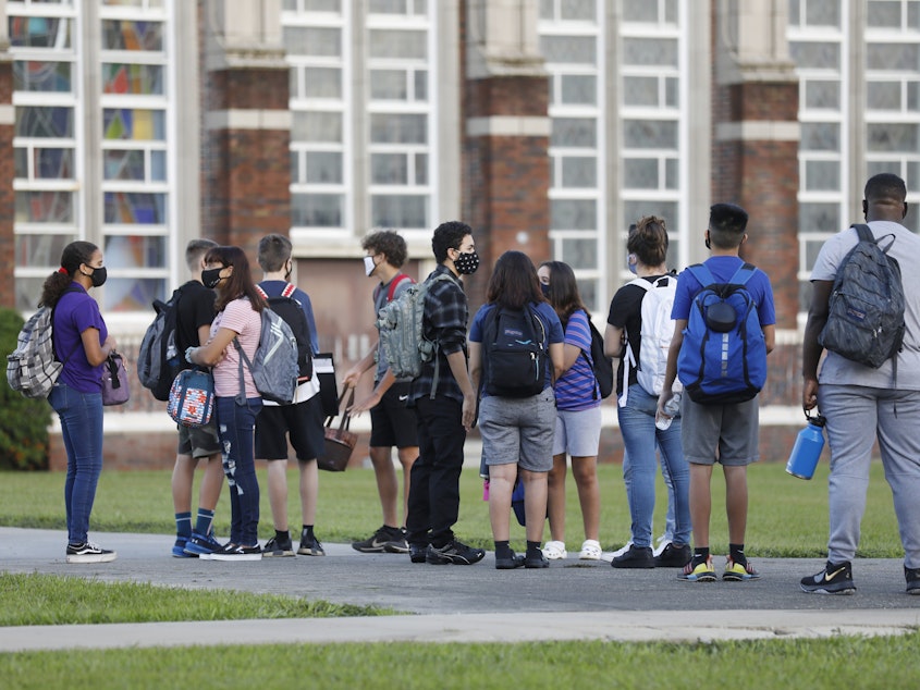 caption: Students at Hillsborough High School in Tampa, Fla., wait in line to have their temperatures checked on Aug. 31. According to an updated tracker, Florida is one of three states that will offer full-time, in-person learning to more than 75% of students by Election Day.