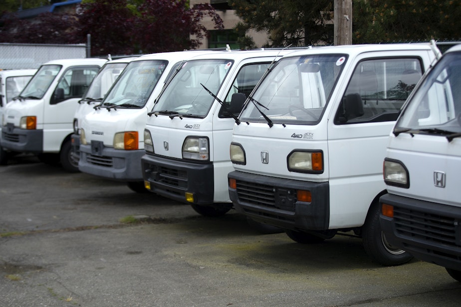 caption: A line of Japanese kei trucks are shown on Tuesday, May 13, 2025, at JDM Car & Motorcycle in Shoreline.