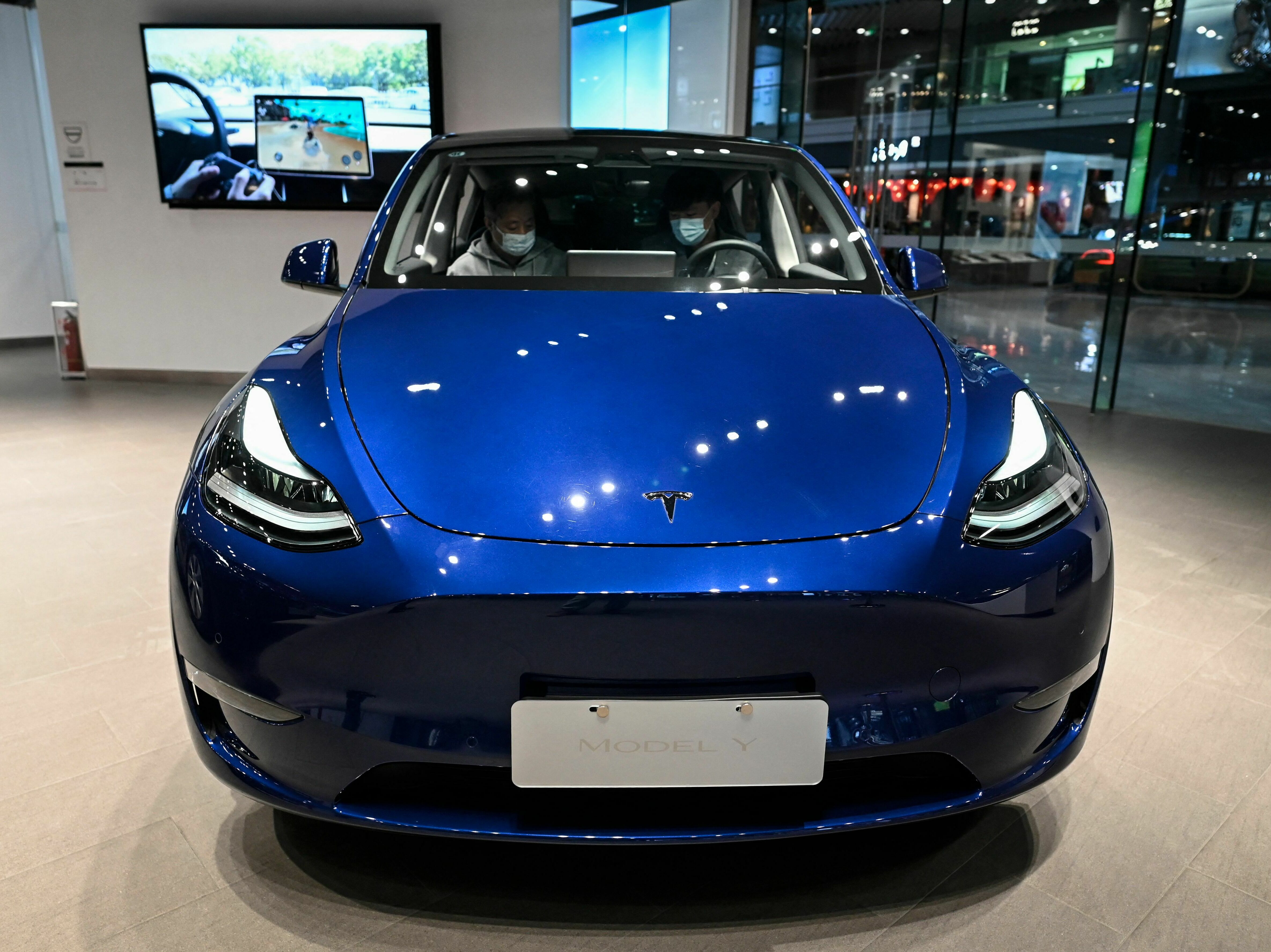 caption: Tesla's Model Y is on display at a Tesla showroom in a shopping mall in Beijing on April 29, 2022. The electric car maker cut prices for its models in a bid to boost sales.
