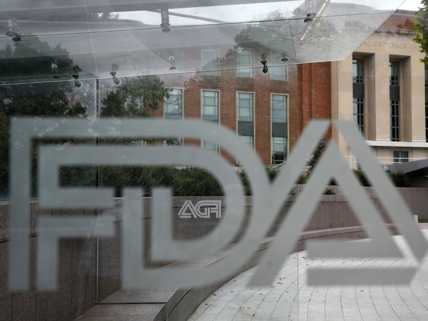 caption: In this Aug. 2, 2018, file photo, the U.S. Food and Drug Administration (FDA) building is visible behind FDA logos at a bus stop on the agency's campus in Silver Spring, Md.