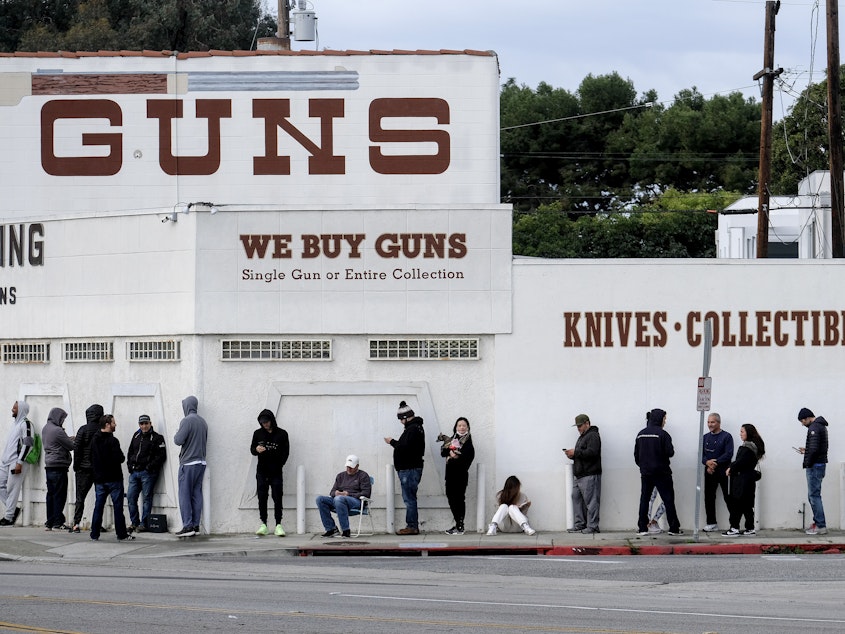 caption: People wait in line to enter a gun store in Culver City, Calif., on March 15, 2020.