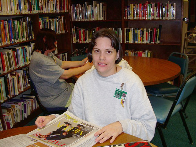 caption: A woman reading in the library of  Gig Harbor's Washington Corrections Center for Women.