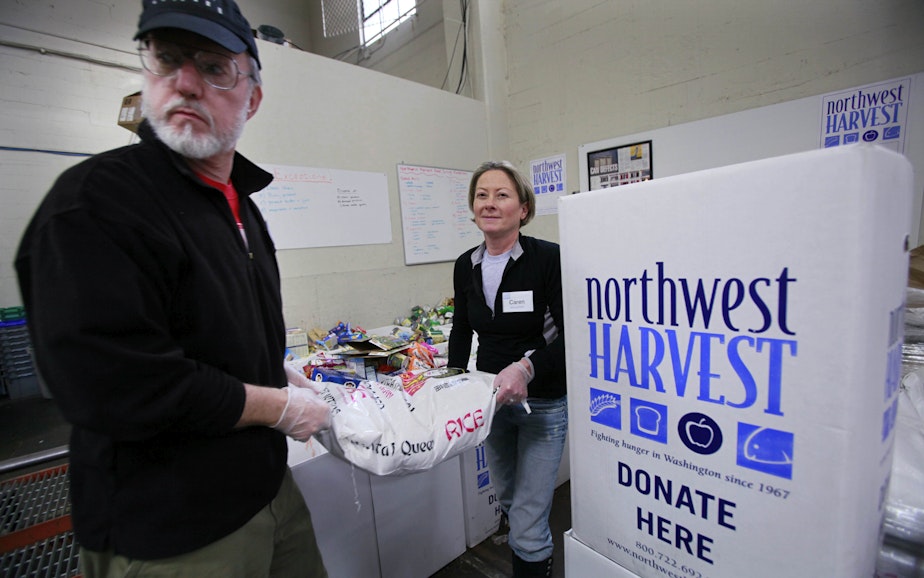 caption: Volunteers Ken Newman, right, and Caren Shepsky heft a 50-pound bag of rice at the Cherry Street Food Bank, run by Northwest Harvest, Wednesday, Nov. 11, 2009, near downtown Seattle. Northwest Harvest, a non-profit hunger relief agency, also provides food for over 300 partner programs state-wide. American charities say they have weathered about a 9 percent drop in giving this year and a recent survey show they may see a decrease in year-end generosity. 