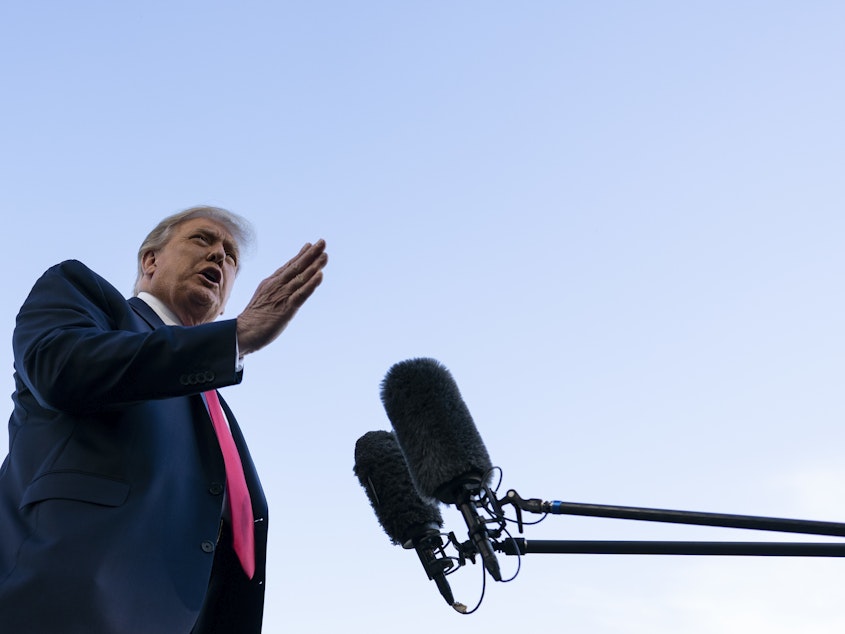 caption: President Trump speaks with reporters on the South Lawn prior to departing the White House on Saturday.