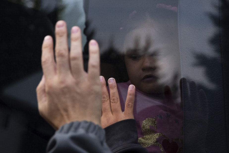 caption: Tynikki Arnold and Sean wave goodbye to Vay as the school bus pulls away for her first day of school, on Monday, September 12, 2022.
