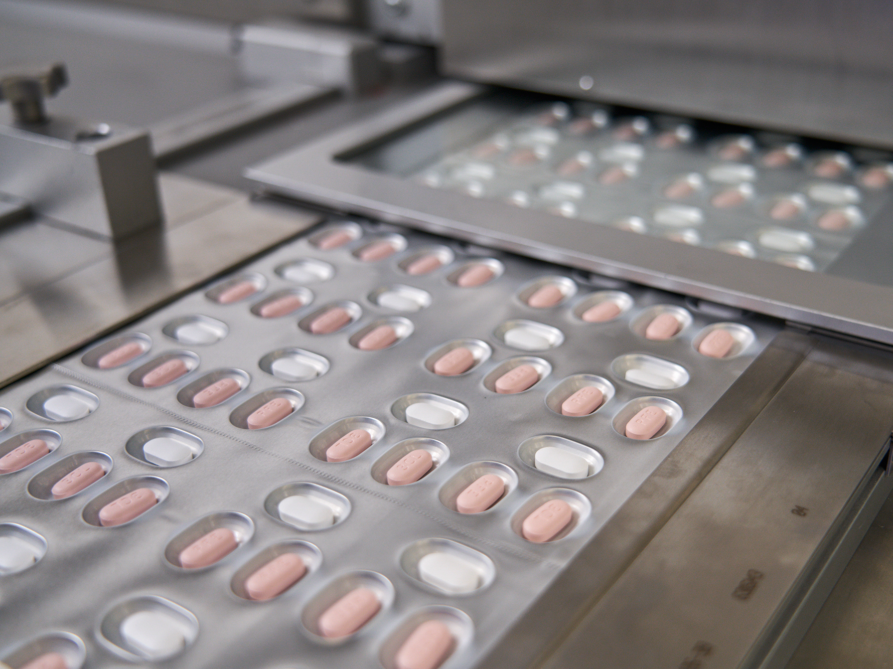 caption: Paxlovid tablets are packaged at a Pfizer factory.
