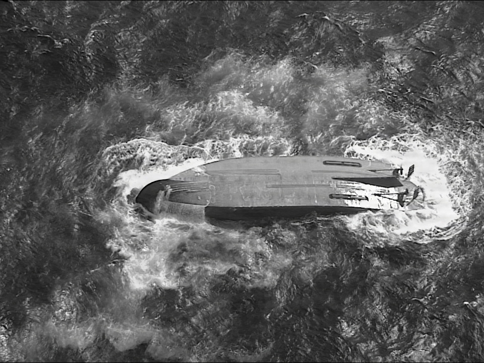 caption: A U.S. Coast Guard HC-130 Hercules airplane crew assigned to Coast Guard Air Station Barbers Point flies over an overturned vessel offshore Saipan, Saturday, April 18, 2026, while searching for a missing vessel, the Mariana, that experienced an engine failure April 15.