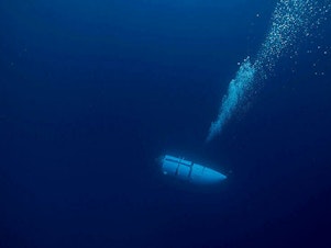caption: An undated photo shows a tourist submersible belonging to OceanGate descending into the ocean. Search and rescue operations for one of the company's submersibles, Titan, are continuing Wednesday.