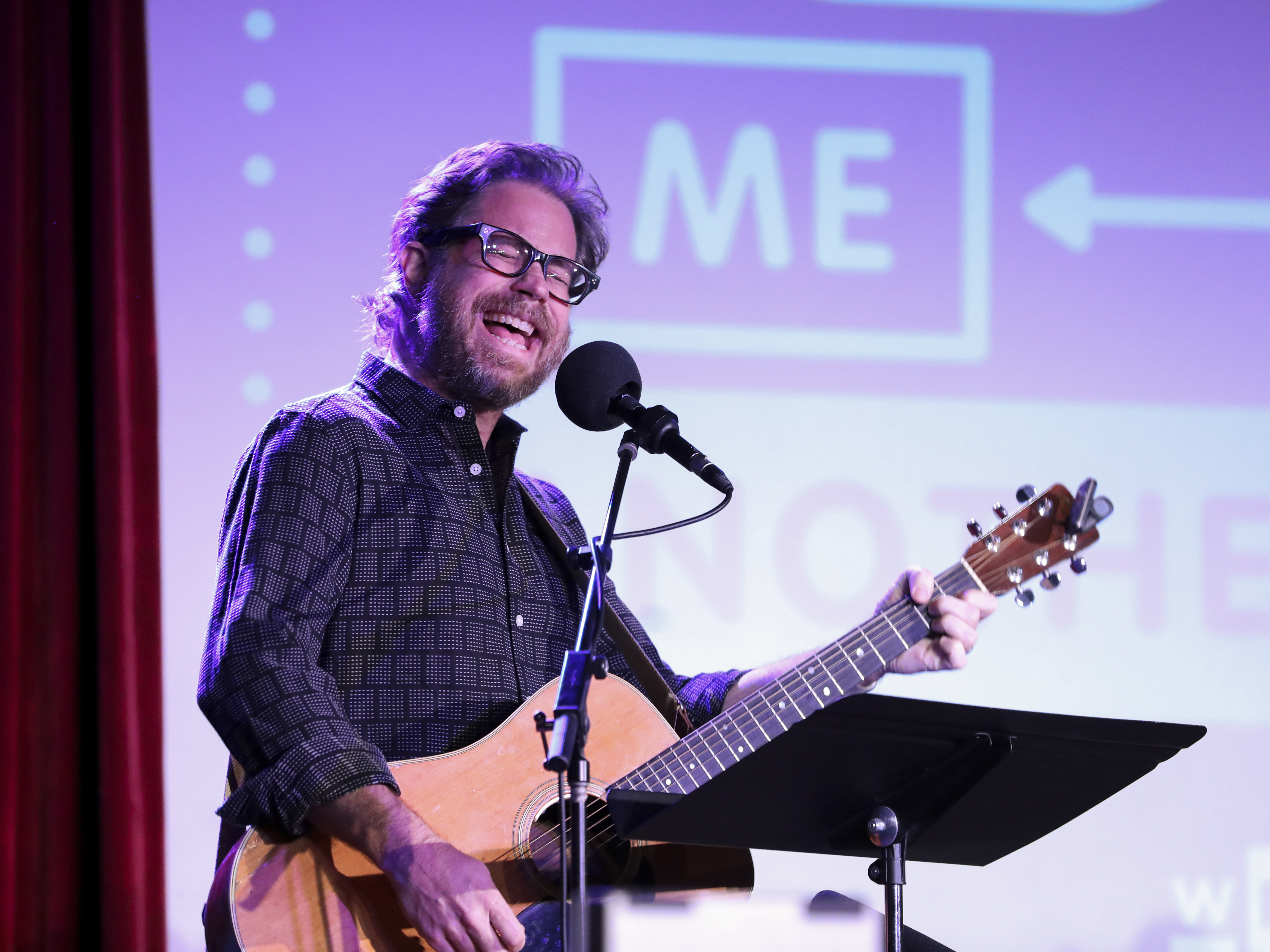 caption: Jonathan Coulton leads a music parody game on <em>Ask Me Another</em> at the Bell House in Brooklyn, New York.