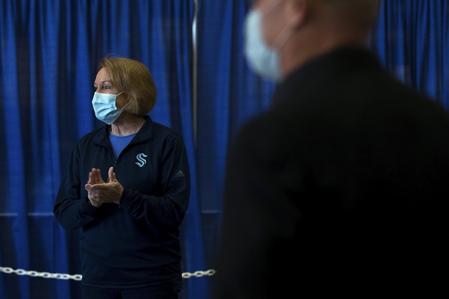 caption: Seattle mayor Jenny Durkan, left, claps as the first patients arrive to be vaccinated against Covid-19 at the new civilian-led mass vaccination site at Lumen Field Events Center on Saturday, March 13, 2021, in Seattle.