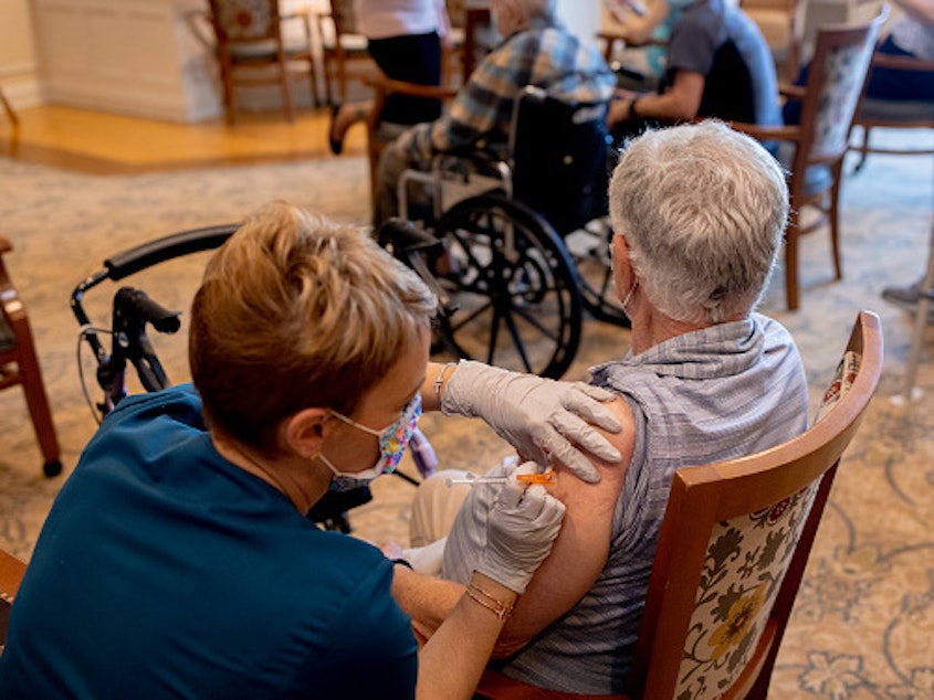 caption: A health care worker administered a third dose of the Pfizer-BioNTech Covid-19 vaccine at a senior living facility in Worcester, Penn., in August.