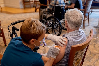 caption: A health care worker administered a third dose of the Pfizer-BioNTech Covid-19 vaccine at a senior living facility in Worcester, Penn., in August.