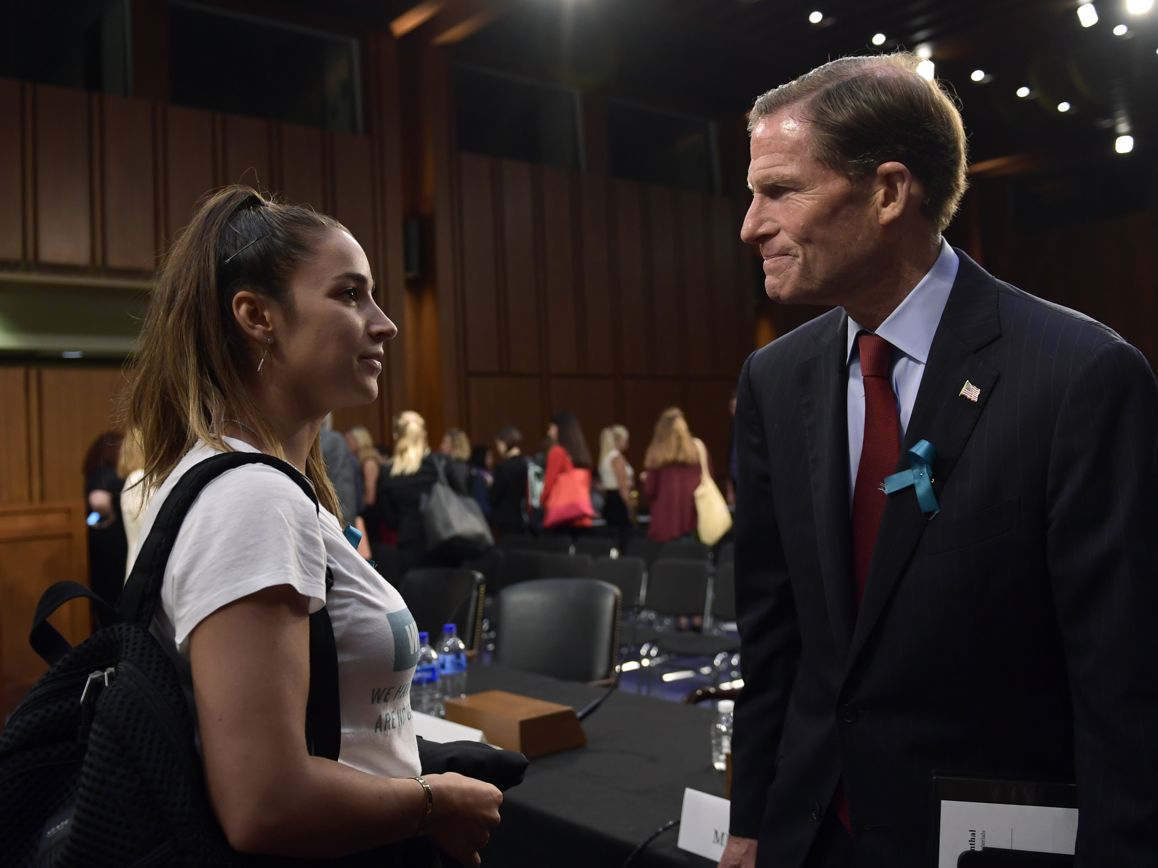 caption: Olympic gold medalist Aly Raisman talks with Sen. Richard Blumenthal, D-Conn., following a 2018 Senate subcommittee hearing on keeping athletes safe from abuse.