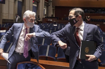 caption: Fed Chairman Jerome Powell and Treasury Secretary Steven Mnuchin bump elbows at the conclusion of their testimony before Congress on June 30, 2020. The Fed and Treasury are engaging in a rare clash over the fate of key pandemic lending programs.