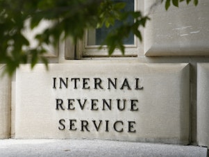 caption: A sign outside the Internal Revenue Service building is seen, May 4, 2021, in Washington. The amount of tax money owed but not paid to the IRS is set to keep growing, according to projections published by the federal tax collection agency.