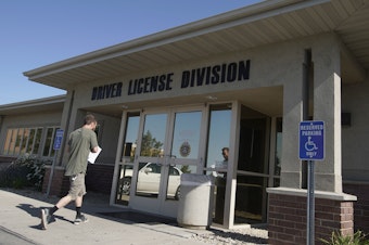 caption: A person walks into a Utah Driver License Division office in July in Orem, Utah.