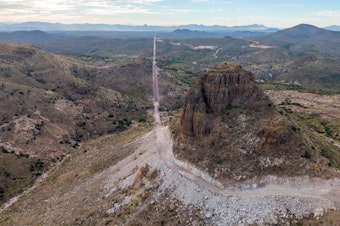caption: In the Guadalupe Canyon in southeastern Arizona, work crews are dynamiting mountainsides and bulldozing access roads in this stunning landscape to make way for the border wall. Mexico is on the left.
