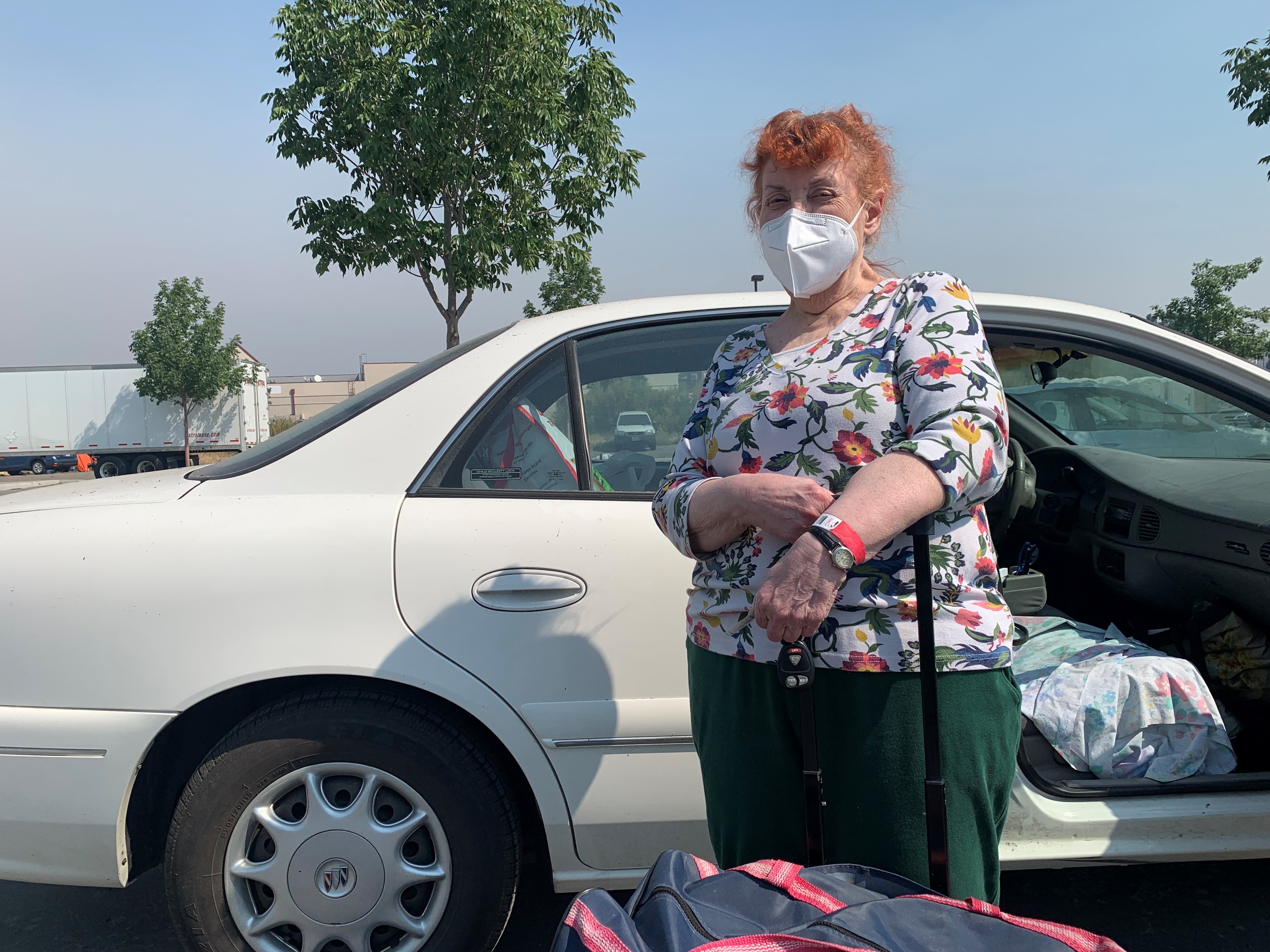 caption: Mimi Routh, 79, unloads a suitcase from her car after evacuating from the Tahoe Senior Plaza to a shelter in nearby Gardnerville, Nev.