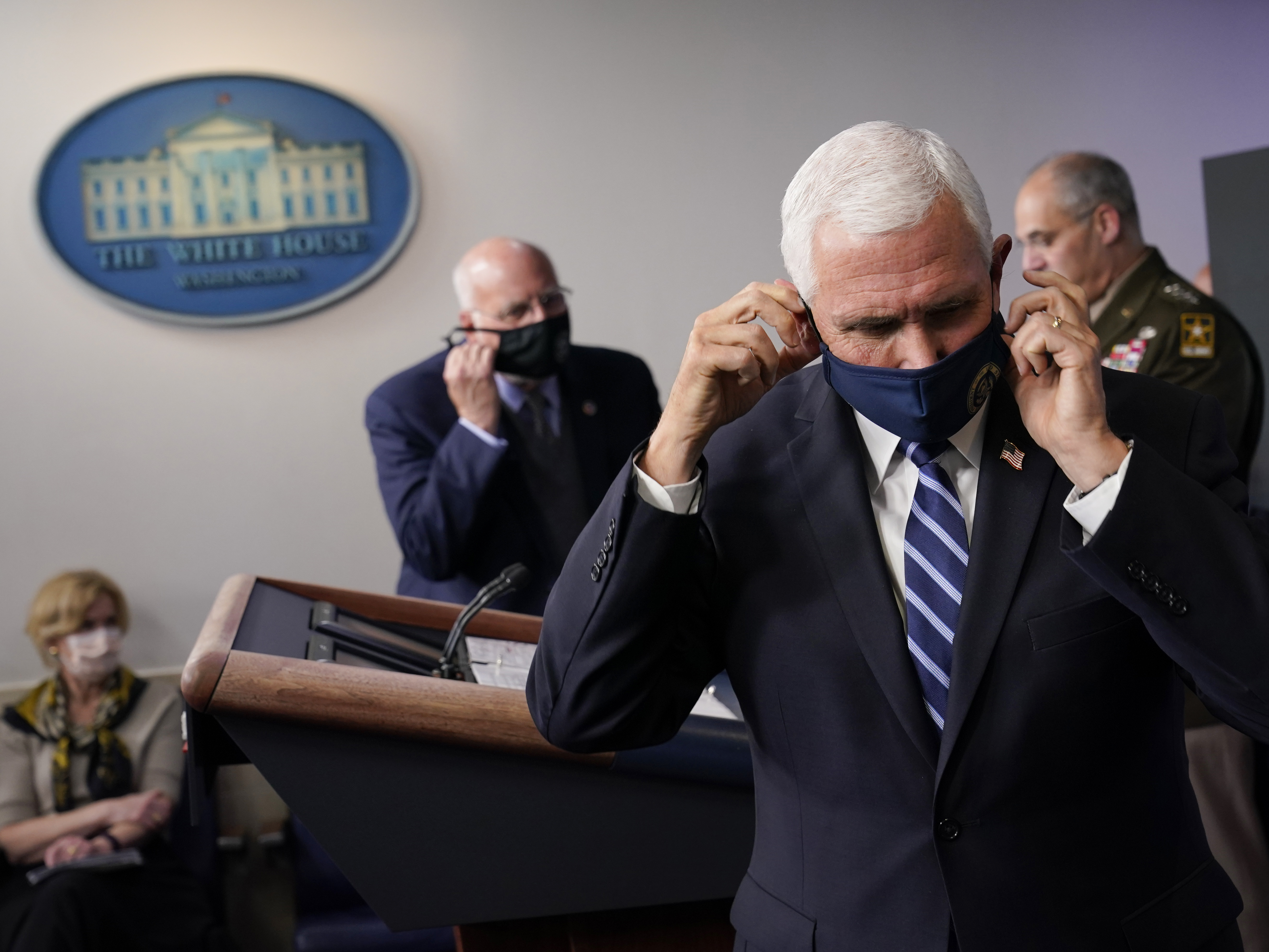 caption: Vice President Pence adjusts his face mask during a news conference with the coronavirus task force at the White House on Thursday.