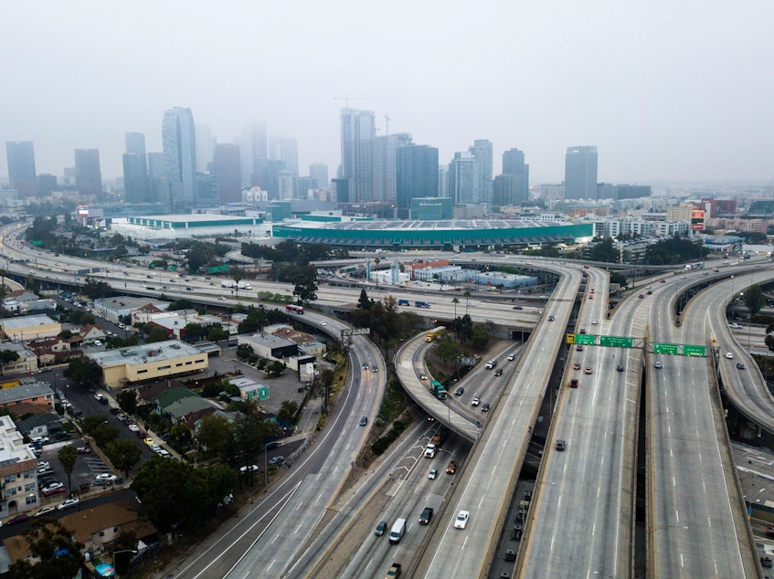 caption: An aerial view shows downtown Los Angeles on April 30. U.S. miles driven decreased remarkably quickly in March, and driving slowly started to resume again — while remaining well below typical levels.