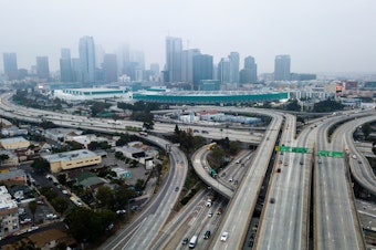 caption: An aerial view shows downtown Los Angeles on April 30. U.S. miles driven decreased remarkably quickly in March, and driving slowly started to resume again — while remaining well below typical levels.