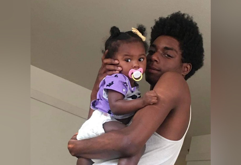 caption: Saylen Kelly, 18, with his daughter. 