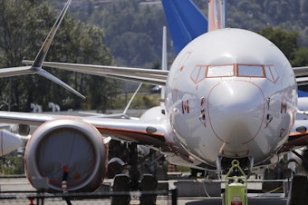 caption: A grounded Boeing 737 Max along with dozens of others crowd a parking area adjacent to Boeing Field in Seattle. Federal safety officials said on Thursday that Boeing should consider how cockpit confusion can slow the response time of pilots.
